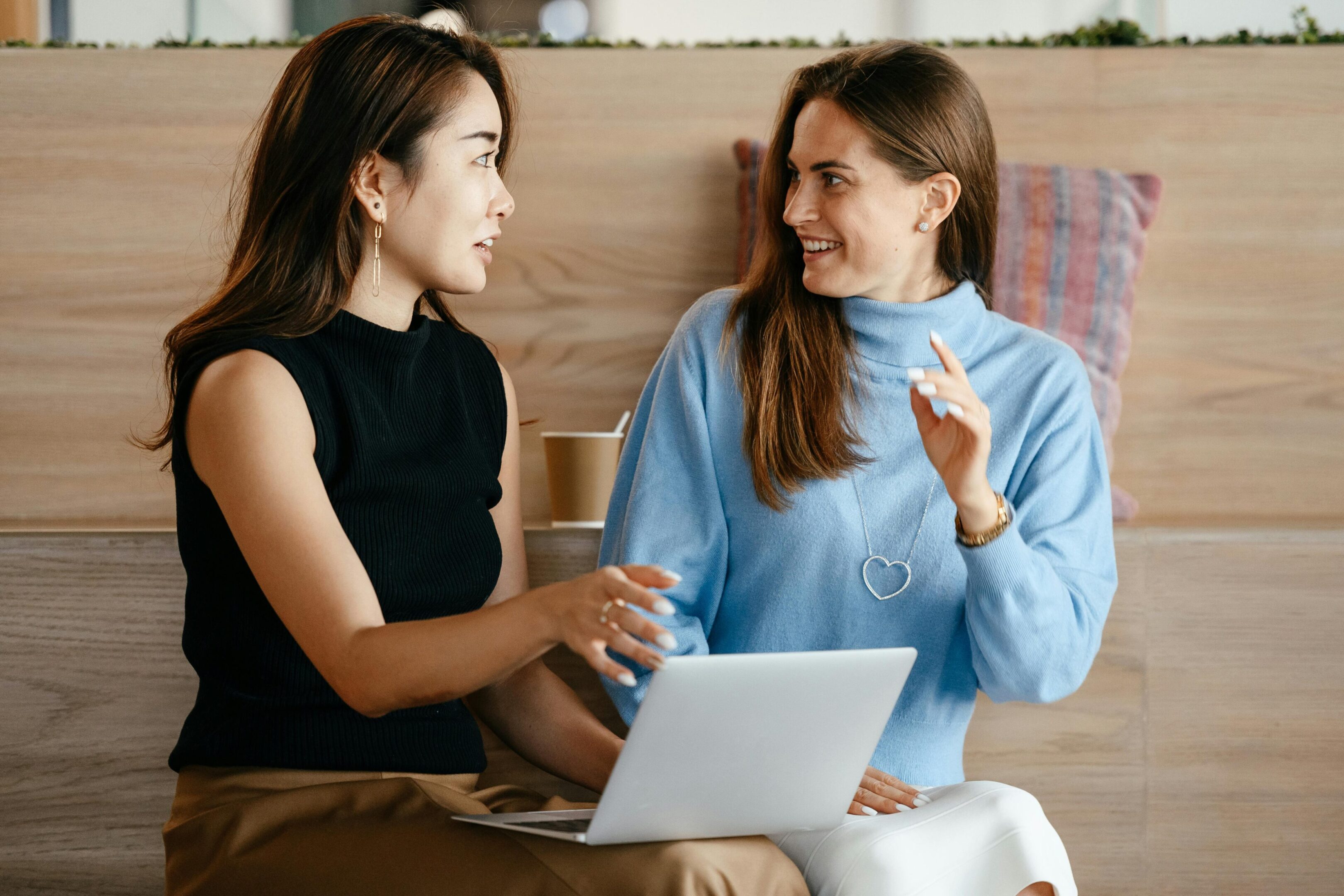 Women discussing work with a laptop