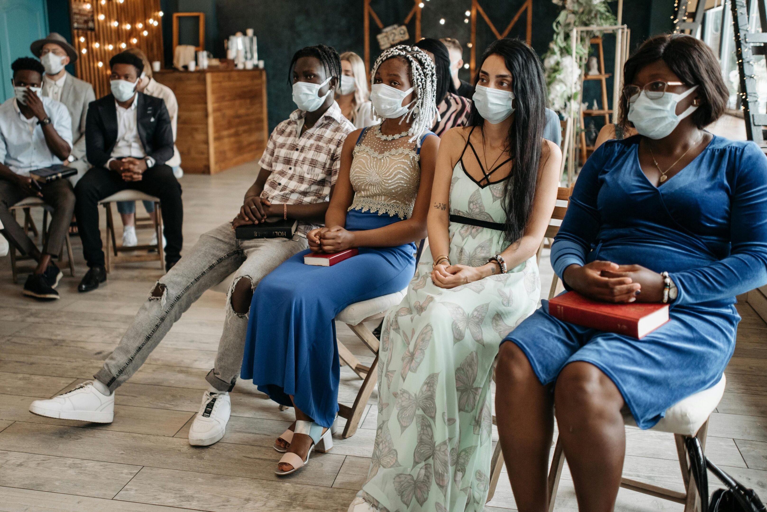 Diverse audience listening attentively, masked faces